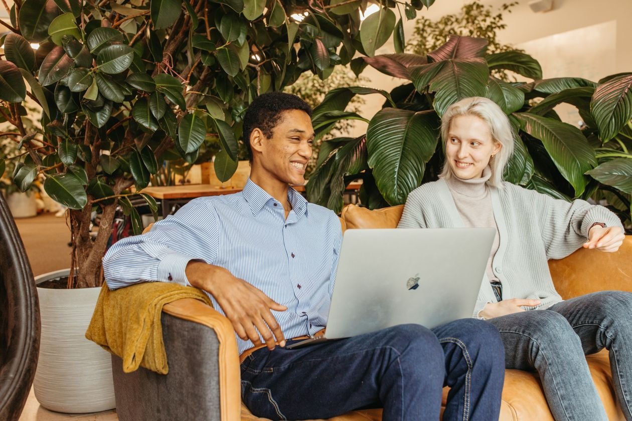 Remote workers on laptops in a bright coworking space with plants
