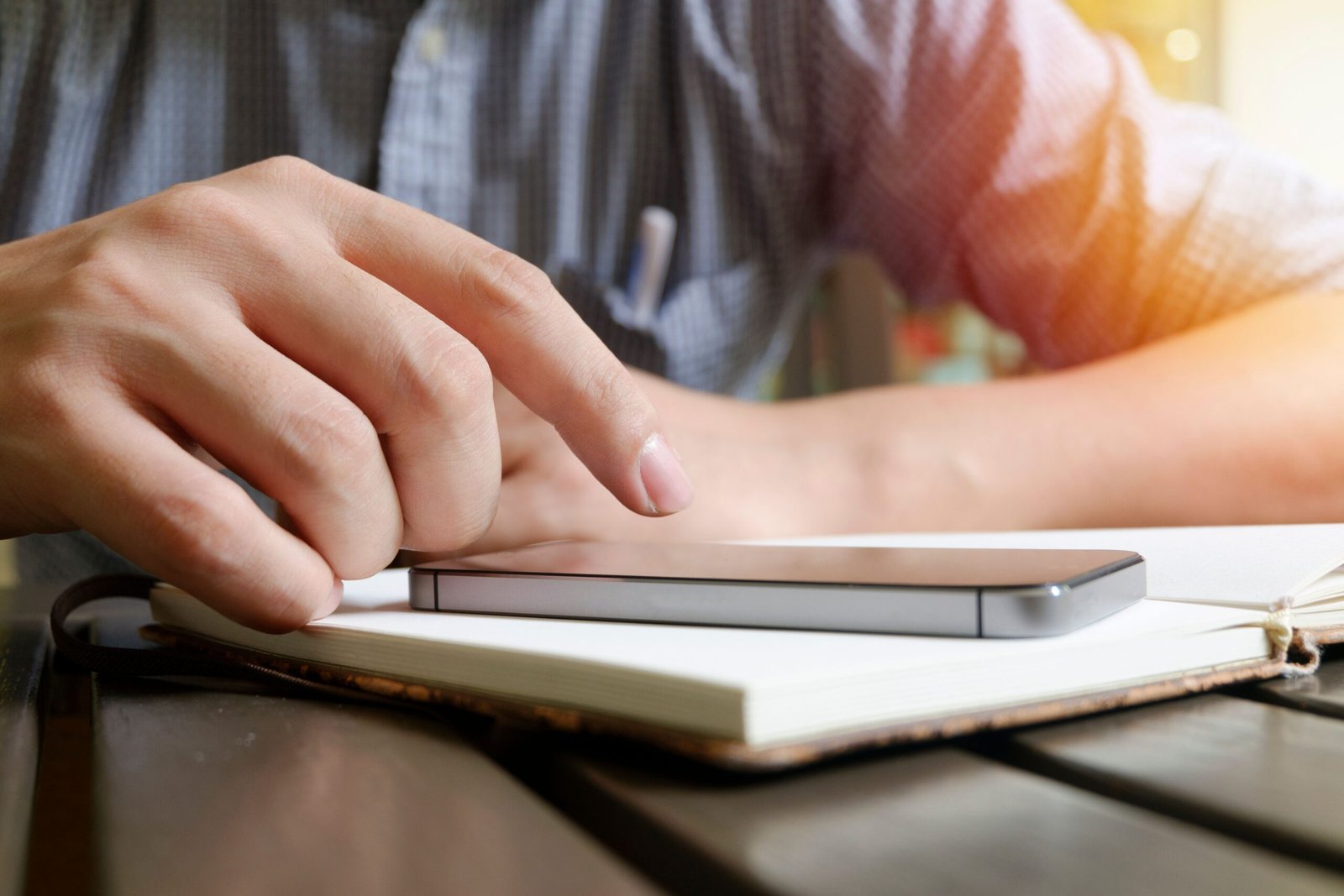 Tampilan dekat tangan yang berinteraksi dengan ponsel pintar mengisi formulir online