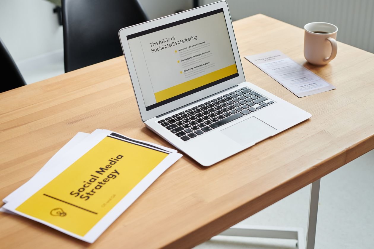 Tampilan dekat laptop yang menunjukkan strategi pemasaran media sosial di lingkungan kantor