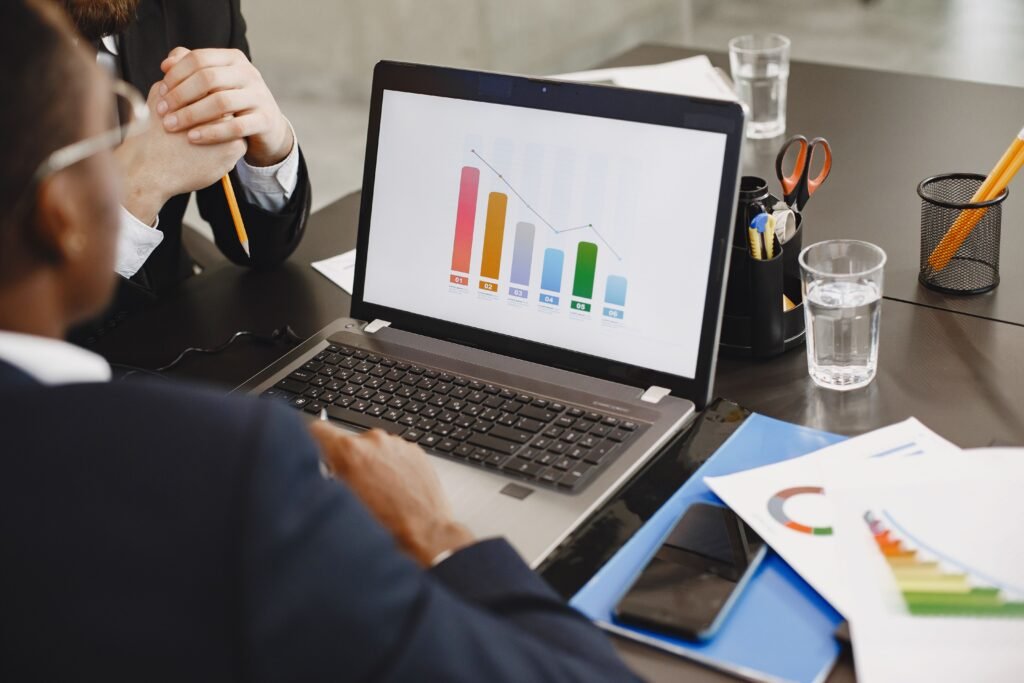Two professionals analyzing a business graph on a laptop during a meeting
