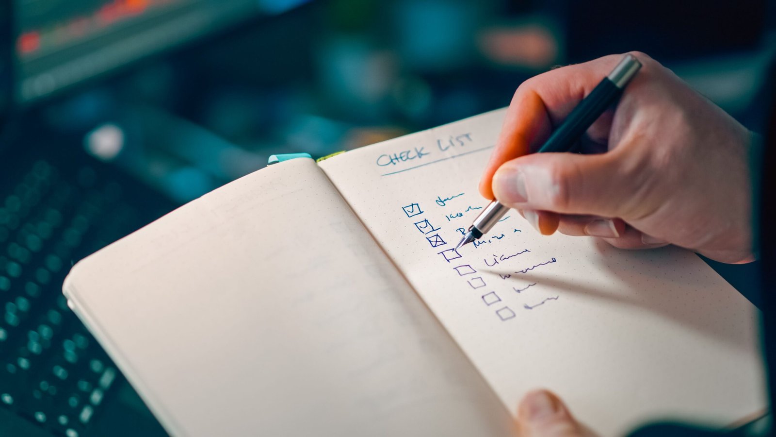 Close-up of a hand writing in a notebook with a checklist for effective task management