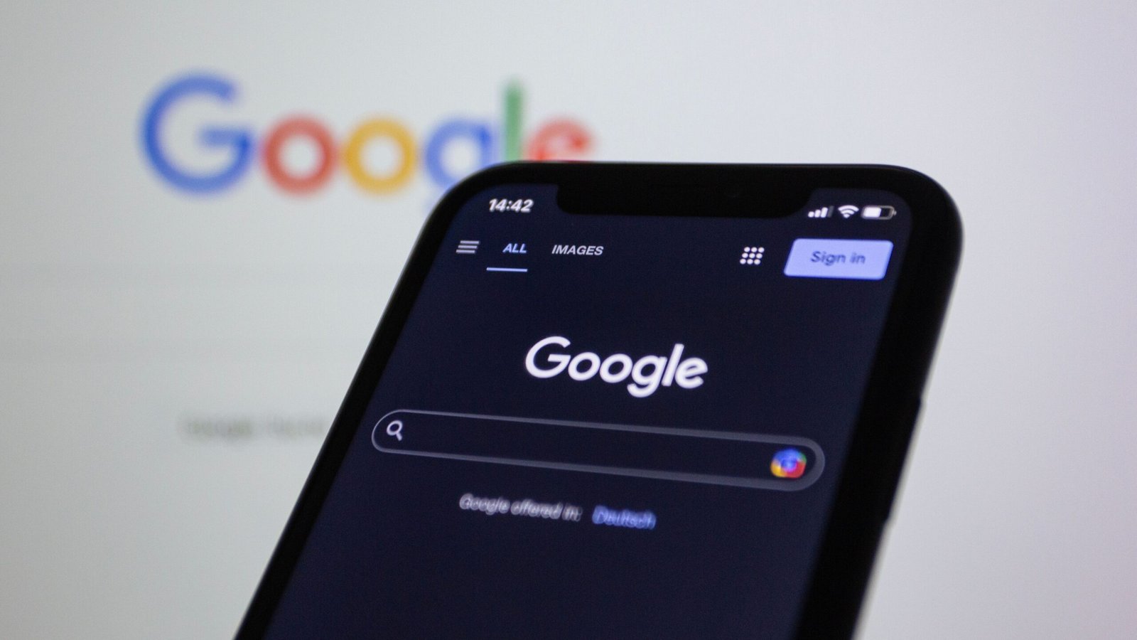 pexels shutter speed 15406292 Smartphone screen showing Google search in dark mode with the Google logo in the background.