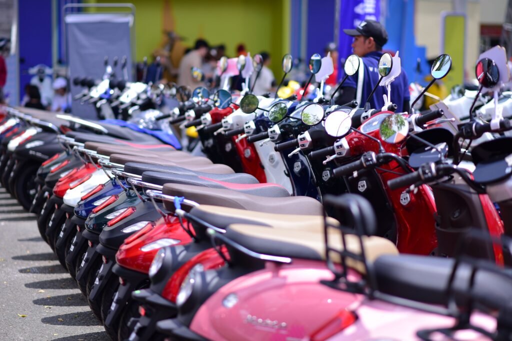 Row of vibrant rental scooters showcasing in various colors, parked outdoors