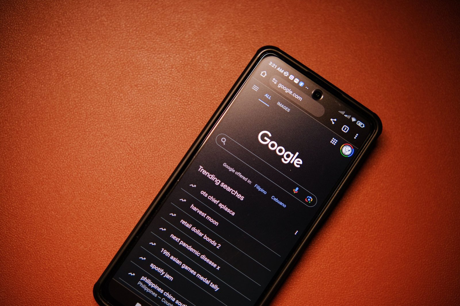 A smartphone displaying Google Search on a table at night