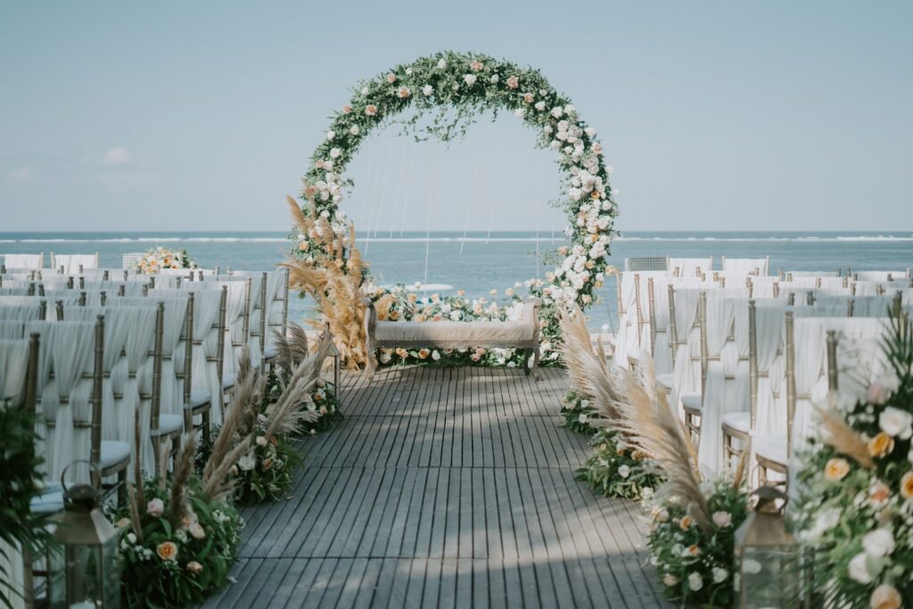 Beautiful beachside wedding setup with elegant floral arch and ocean backdrop